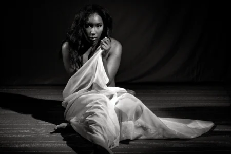 Quiet Form Black and white seated figure study of a woman draped in white fabric