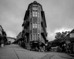 The Flatiron Building, Eureka Springs, Arkansas Black and white photograph of the Flatiron Building at a steep street intersection in Eureka Springs, Arkansas.