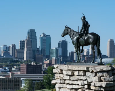 The Scout statue stands above Kansas City, linking local history with the modern skyline. Equestrian statue overlooking the Kansas City skyline on a clear day.