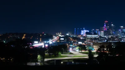 Kansas City glows at night with skyline lights and moving traffic. Kansas City skyline at night with bright city lights and traffic.
